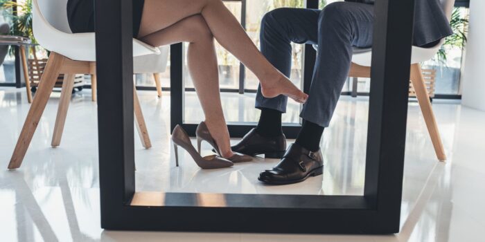 Woman flirting with man under table