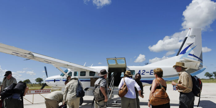 Selinda Concession,Botswana - March 29, 2012: Tourists ready to board the airplane Cessna Aircraft Grand Caravan 208 B from Wilderness Air  leaving the Selinda Concession for another destination in the Okavango Delta.