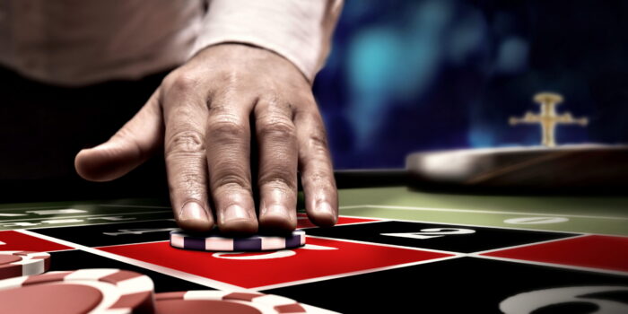 hand betting on roulette number at casino table
