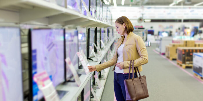 woman chooses a TV in the store